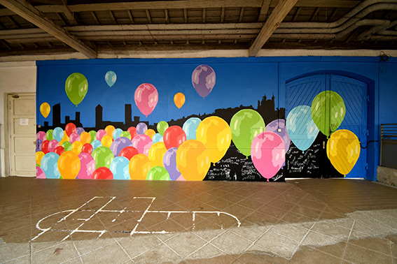 Vue intégrale de la fresque représentant un lâcher de ballons multicolores avec en second plan les principaux monuments de Lyon en silhouette noire - 2 